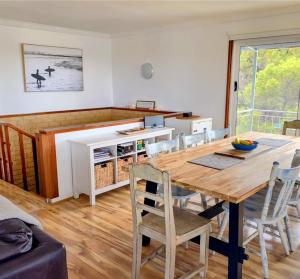 une cuisine et une salle à manger avec une table et des chaises en bois dans l'établissement Falcon Bay Family Retreat, à Falcon