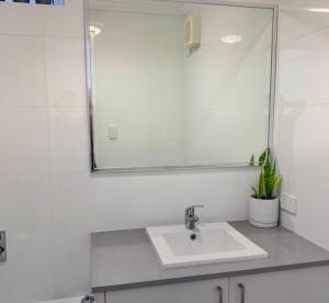 une salle de bain avec un lavabo et un miroir dans l'établissement Falcon Bay Family Retreat, à Falcon 27 autres photos