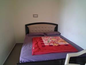 a bed with a red blanket on it in a room at Hotel O Hill Top Hotel in Vānivilāsa Puram +32 photos