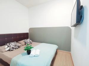 ein Zimmer mit einem Bett und einem Fernseher an der Wand in der Unterkunft 2pax Room Near ECM KCM STADIUM in Kuantan