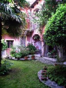 an old house with a yard with plants and trees at Wohnung Caprifoglio In Miasino in Miasino