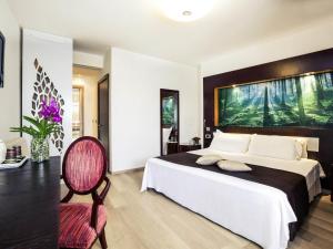 a bedroom with a large bed and a chair at Mercure Olbia in Olbia