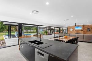 an open kitchen and living room with a dining area and a table at Racecourse Resort in Darawank