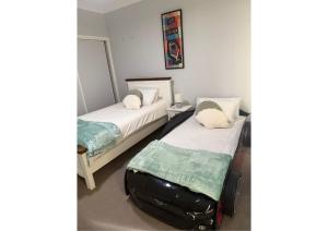 a room with two beds and a suitcase at Racecourse Resort in Darawank