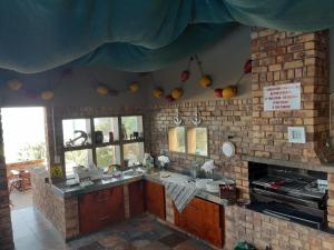 een keuken met 2 wastafels en een bakstenen muur bij The Albatros Guesthouse in Margate