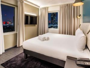 a hotel room with a large bed and a window at ibis London Blackfriars in London