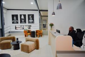 a man sitting at a desk in an office with a laptop at The Anza Lifestyle Lodge in Louis Trichardt