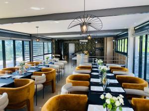 a restaurant with long tables and chairs and windows at The Anza Lifestyle Lodge in Louis Trichardt