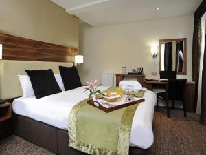 Una habitación de hotel con una cama grande y un escritorio. en Mercure London Bloomsbury Hotel, en Londres