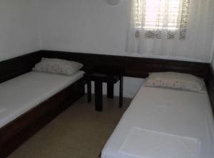a small room with two beds and a window at Apartments Miki Rogoznica in Podglavica