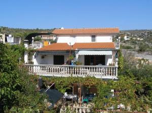 a person standing on a balcony of a house at Apartments Miki Rogoznica in Podglavica