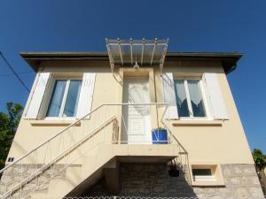 ein weißes Haus mit einer weißen Tür und einer Treppe in der Unterkunft Cozy Garden Retreat Malemort in Malemort-sur-Corrèze