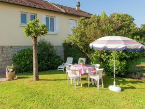 einen Tisch und einen Regenschirm im Hof eines Hauses in der Unterkunft Cozy Garden Retreat Malemort in Malemort-sur-Corrèze