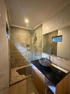 łazienka z umywalką i prysznicem w obiekcie Annayu House Ubud w mieście Ubud