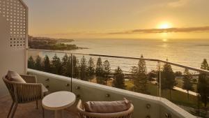 un balcón con vistas al océano al atardecer en InterContinental Sydney Coogee Beach by IHG, en Sídney
