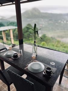 une table avec deux plaques et un vase avec une plante sur la table dans l'établissement ATJ The Hideout, à Vagamon