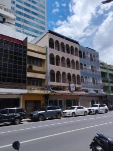 un edificio con auto parcheggiate sul lato di una strada di Starhouse a Hat Yai