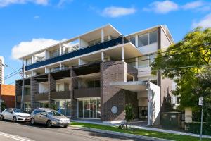 an apartment building on the corner of a street at Ultra modern 2 bdrm in St Leonards Crows Nest - 803NOR in Sydney