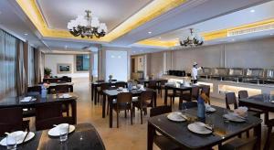 a dining room with tables and chairs in a restaurant at Vienna Hotel Fujian Yong'an South Railway Station in Yong'an