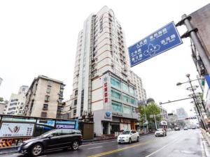 a street sign with cars driving down a city street at Jinjiang Inn Xiaoshan Hangzhou Paradise in Xiaoshan