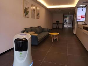a living room with a couch and a hair dryer at Green Tree Inn Liaoning Shenfu New District in Mantangmanzuxiang