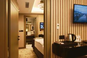 um quarto de hotel com uma cama e uma televisão na parede em Mery Hotel İstanbul em Istambul