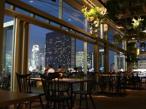 a restaurant with tables and chairs and a view of the city at Shinjuku Granbell Hotel in Tokyo