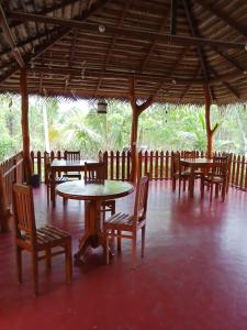 a dining area with tables and chairs and trees at Rock Pool Residence in Tangalle +89 photos