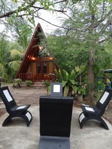 two chairs in front of a small cabin at Rock Pool Residence in Tangalle