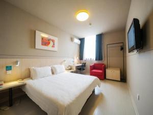 a hotel room with a bed and a desk and a tv at Jinjiang Inn Nantong Gongnong Road in Nantong