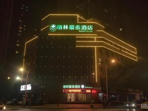 a building with a sign on top of it at night at GreenTree Inn Xiaoyi Wanda Plaza in Yaopu