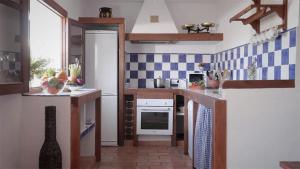 a kitchen with blue and white tiles on the wall at Casa Entre Armonías in Zahara de los Atunes