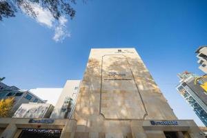 a tall building in a city with a blue sky at Wonju Bellino Hotel in Wonju