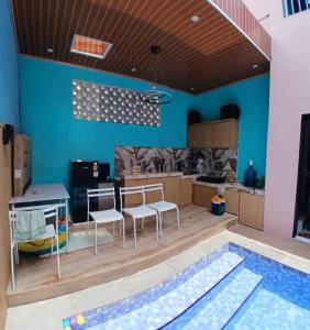 une cuisine aux murs bleus et une piscine dans l'établissement Homestay keluarga solo or solo's family homestay, à Purwosari