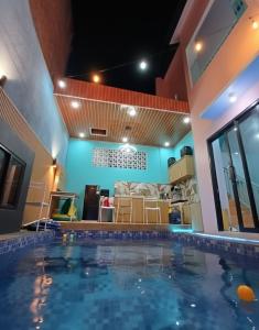 une grande piscine dans une chambre avec une maison dans l'établissement Homestay keluarga solo or solo's family homestay, à Purwosari