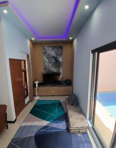 un salon avec une pièce avec une télévision et un plafond dans l'établissement Homestay keluarga solo or solo's family homestay, à Purwosari