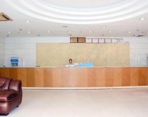 a man sitting at a counter in a waiting room at Yidun Hotel Foshan Luocun in Huanshi