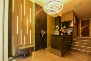 a lobby with a chair and stairs and a chandelier at Mery Hotel İstanbul in Istanbul