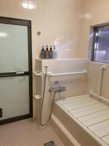 a bathroom with a shower with a tub and a toilet at お宿とごはん百々 in Tanabe +45 photos