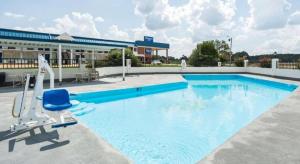 a large swimming pool with a chair and a building at Rodeway Inn Sardis in Sardis