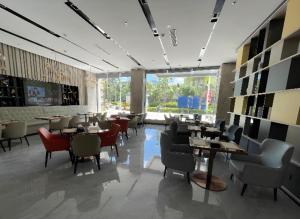 a restaurant with tables and chairs and a large window at Echarm Hotel Changjiang Shilu in Baomei