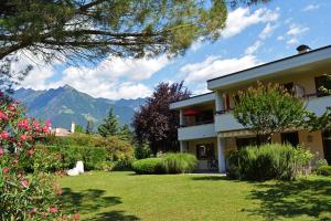 a house with a garden and mountains in the background at Appartement Huber in Merano