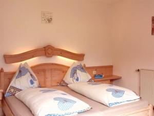a bedroom with a wooden bed with two pillows at Ferienwohnung Gsenger In Abtenau in Abtenau