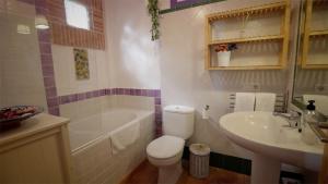 a bathroom with a toilet and a tub and a sink at Casa Entre Armonías in Zahara de los Atunes