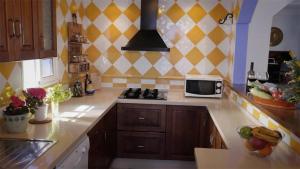 a kitchen with a stove and a microwave at Casa Entre Armonías in Zahara de los Atunes