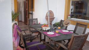 a dining room with a wooden table and chairs at Casa Entre Armonías in Zahara de los Atunes