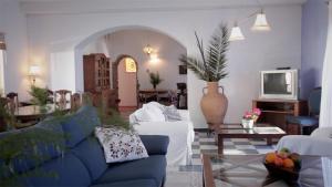 a living room with a blue couch and a tv at Casa Entre Armonías in Zahara de los Atunes