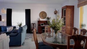 a living room with a table and a blue couch at Casa Entre Armonías in Zahara de los Atunes