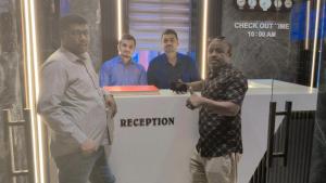 ムンバイにあるNew Hotel Nationalのカウンターの横に立っている男性グループ