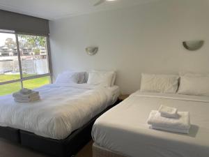 two beds sitting next to each other in a bedroom at Yarrawonga Lakeside Apartment 23 in Mulwala +6 photos